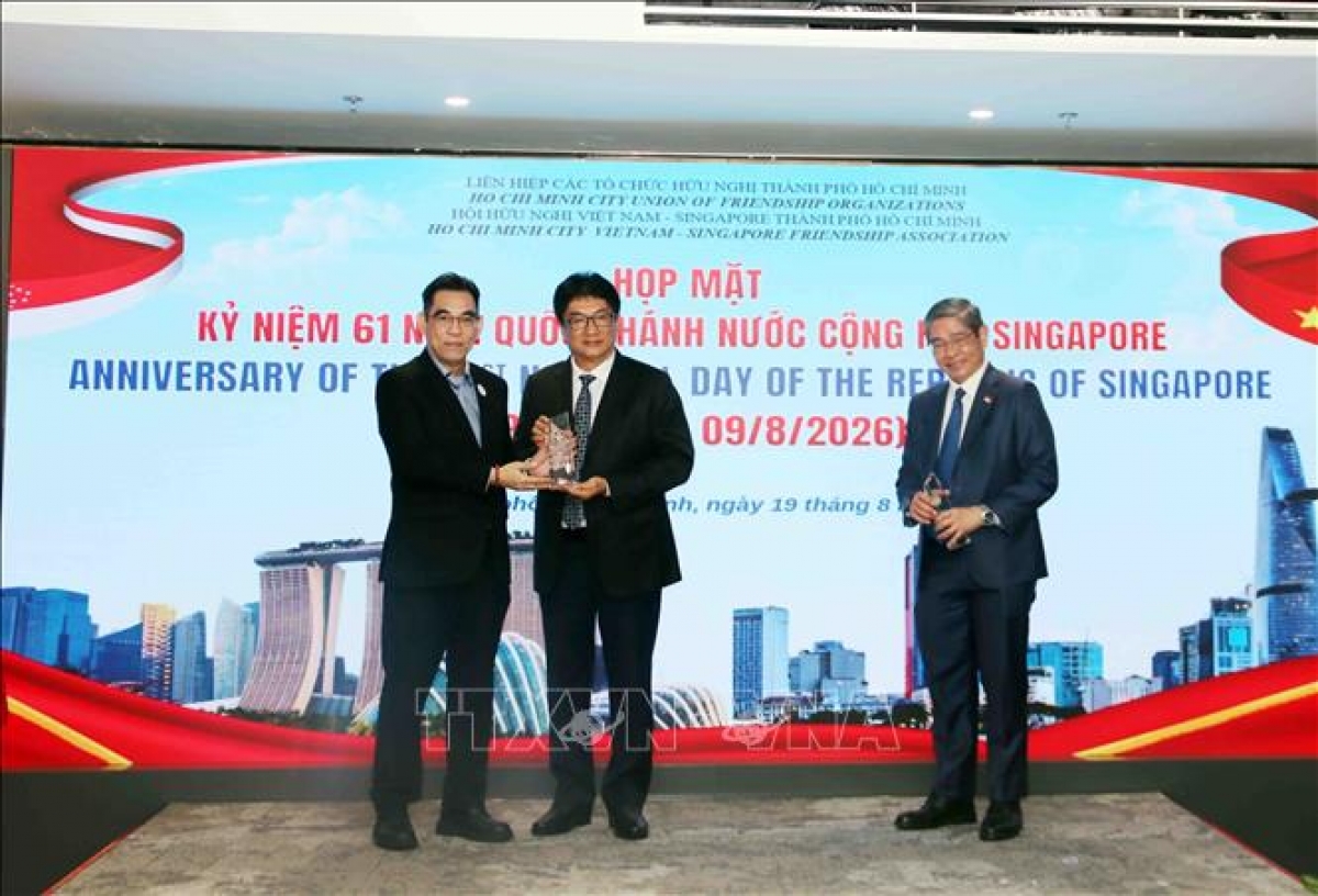 Ho Chi Minh City's representative gives gifts to Chairman of the City’s Vietnam-Singapore Friendship Association Lam Dung Tien (center) and Consul General of Singapore in Ho Chi Minh City Pang Te Cheng (R) (Photo: VNA)
