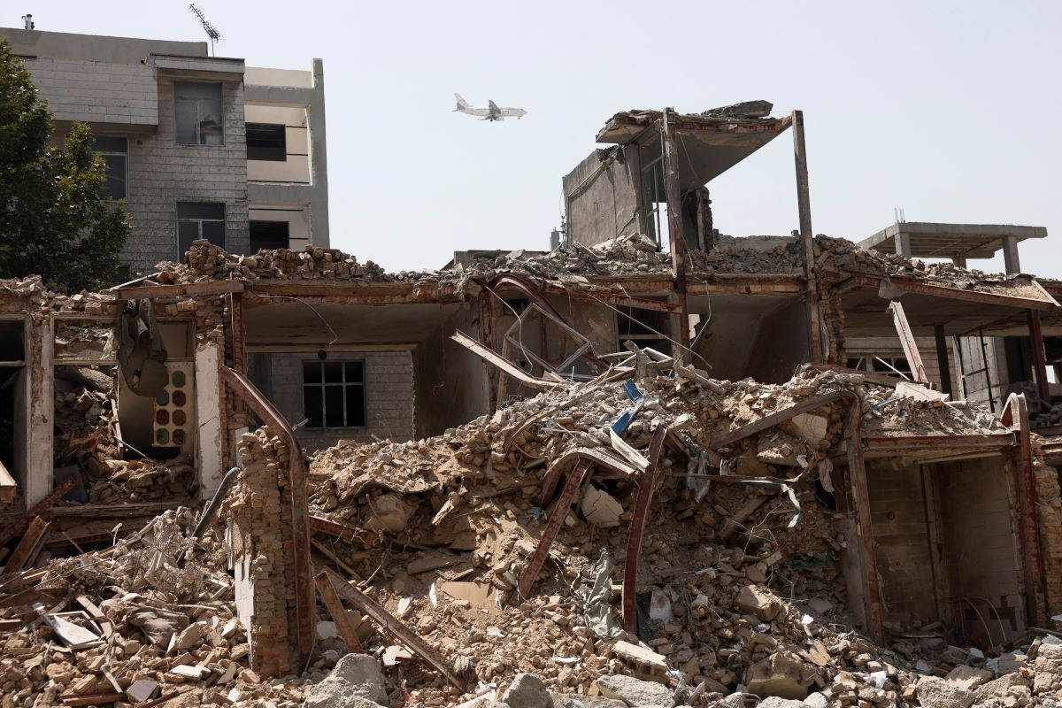 Un avion survole un bâtiment endommagé lors d’une frappe américano-israélienne en mars, à Téhéran, en Iran, le 22 août 2026.  Photo: Majid Asgaripour/WANA (West Asia News Agency) via REUTERS