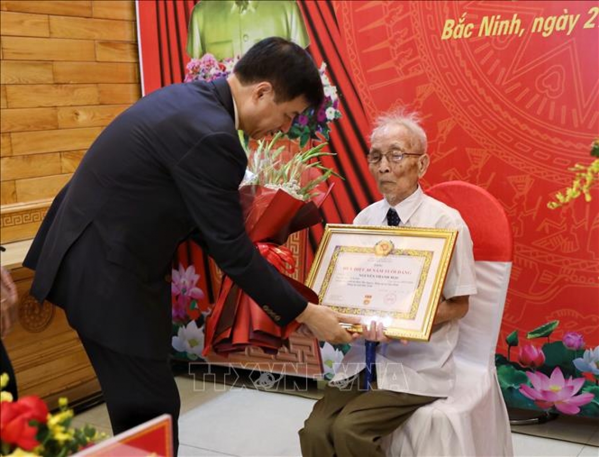 Ông Nguyễn Duy Ngọc, Ủy viên Bộ Chính trị, Bí thư Trung ương Đảng, Trưởng ban Tổ chức Trung ương, trao tặng Huy hiệu 80 năm tuổi Đảng cho ông Nguyễn Thanh Mậu. Ảnh: Danh Lam/TTXVN