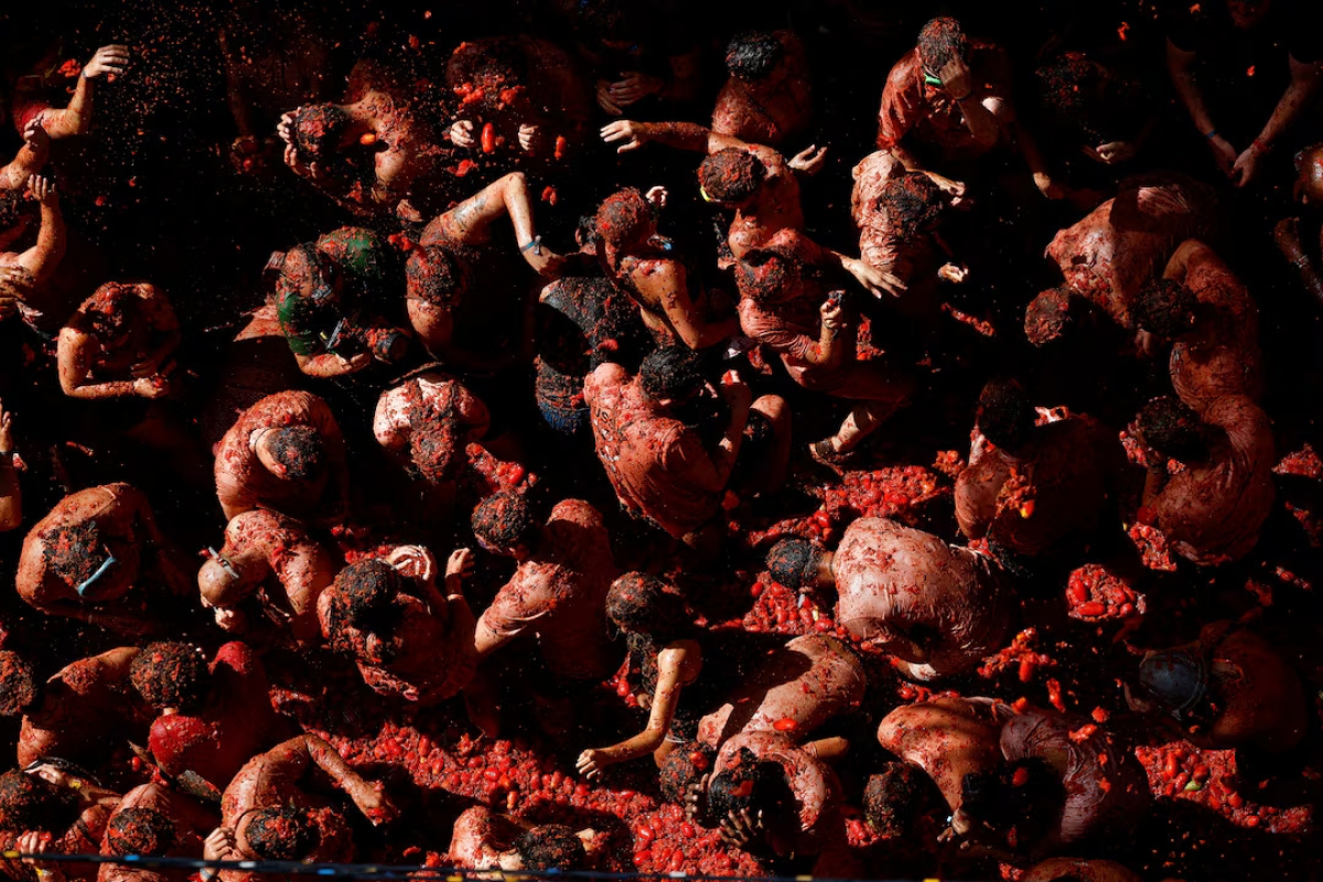 Attendees play in tomato pulp during the annual "La Tomatina" food fight festival in Bunol, Spain, on August 31, 2022. (Photo: REUTERS/Juan Medina)