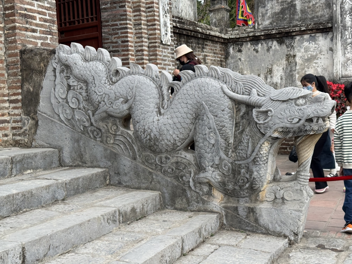 Rồng đá (bên phải) thành bậc đền Thượng ở Khu di tích Cổ Loa (Đông Anh, Hà Nội) có niên đại năm 1732 (thời Lê Trung Hưng), được công nhận là Bảo vật quốc gia năm 2024