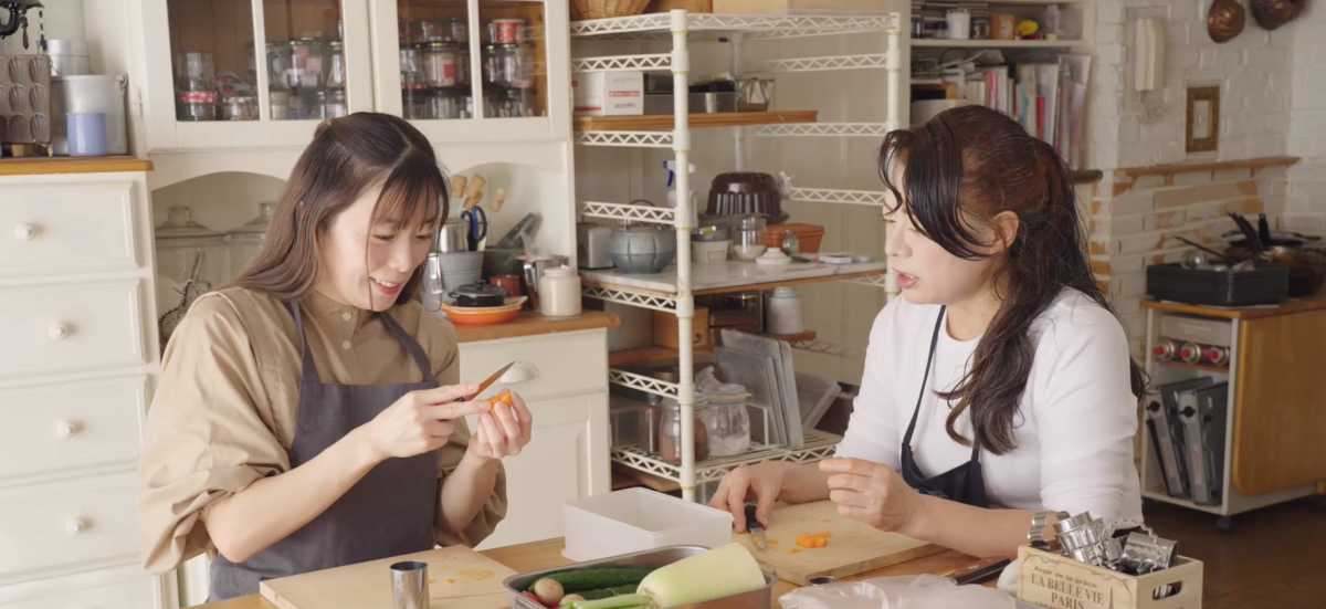 
Artisan Kumagai Mayumi (R) guides a learner in carving flowers from carrots. (Photo: Embassy of Japan)

