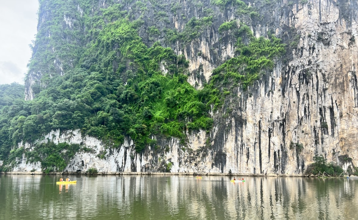 Limestone mountains cast their reflection on the water. (Photo: The Hung/VOV5)
