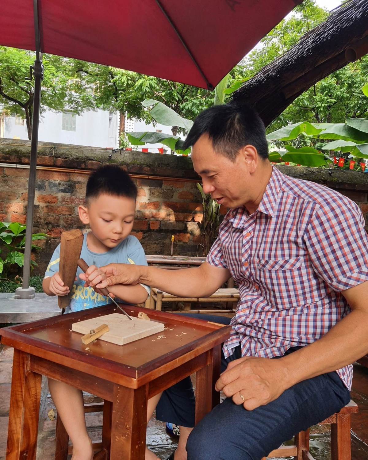 Un moment en famille lors de l’atelier. Photo: Tranh gỗ Bùi Gia