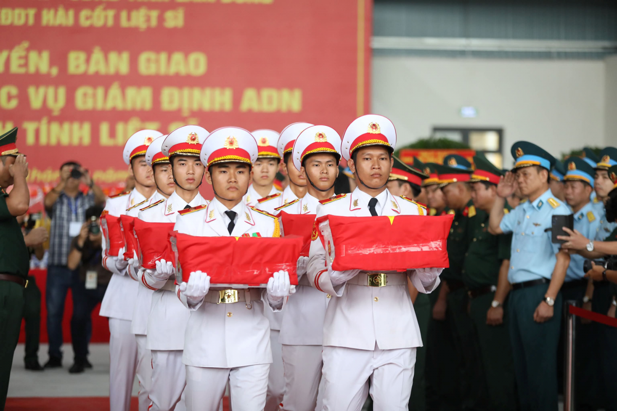  Đội hình tiêu binh trang nghiêm chuyển các hộp chứa mẫu hài cốt liệt sĩ ra máy bay vận tải quân sự tại sân bay Tân Sơn Nhất. Ảnh: N.D