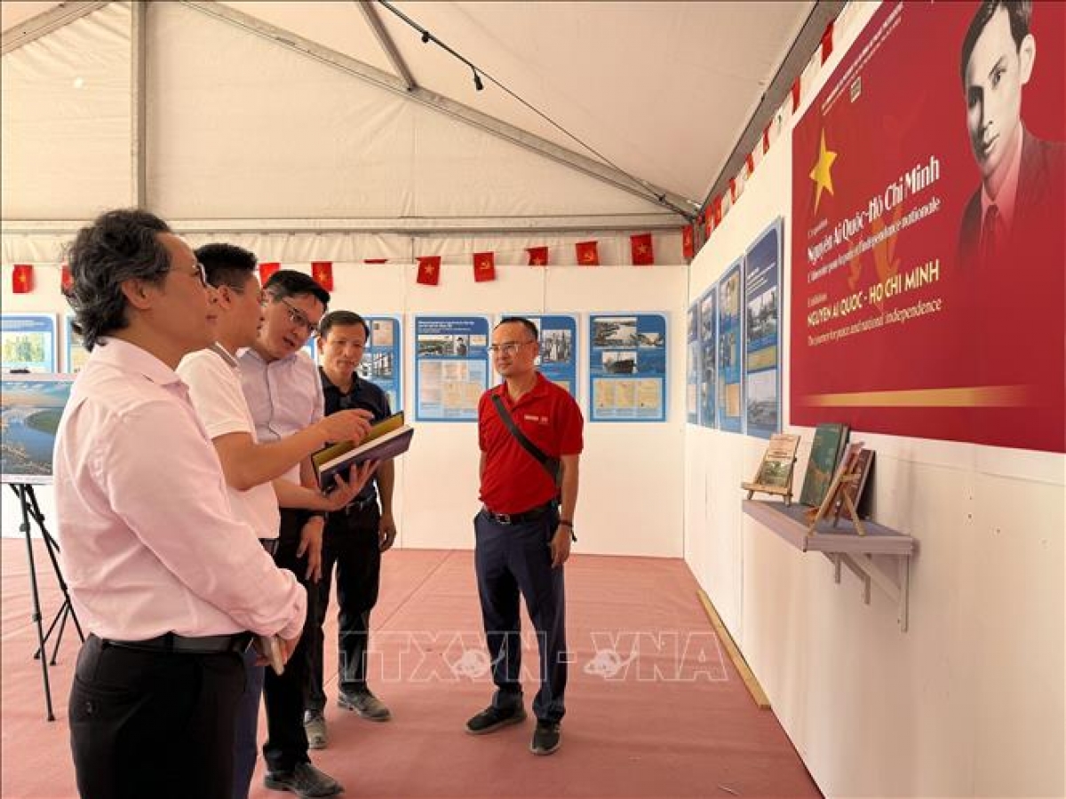 Representantes del periódico Nhan Dan (El Pueblo) presentan el contenido de la exposición sobre el presidente Ho Chi Minh y la lucha de Vietnam por la independencia al embajador de Laos en Francia, Kalamoungkhoune Souphanouvong (centro). Foto: Huu Chien/VNA