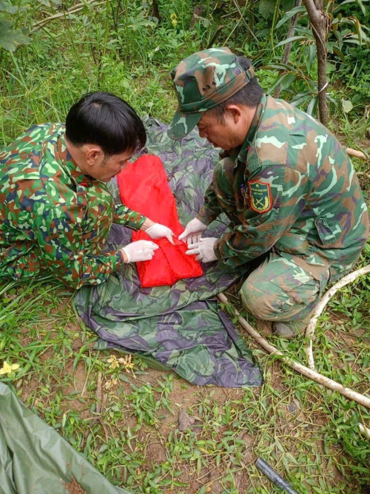 Soldiers carefully wrap the remains of fallen soldiers in Dak Pek Commune, Quang Ngai Province. (Photo: VOV)