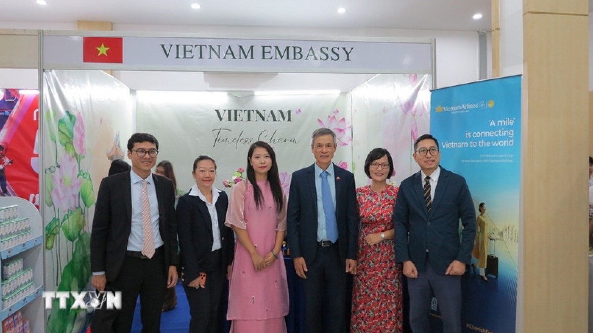 ឯកអគ្គរដ្ឋទូតលោក ង្វៀន មិញ វូ (ទីបីរាប់ពីស្តាំ) ថតរូបជាមួយបុគ្គលិកស្ថានទូត និងតំណាងធុរកិច្ចនៅស្តង់តាំងពិព័រណ៍វៀតណាម (រូបថត៖ មិញ ហ៊ុង/ទីភ្នាក់ងារសារព័ត៌មានវៀតណាម)