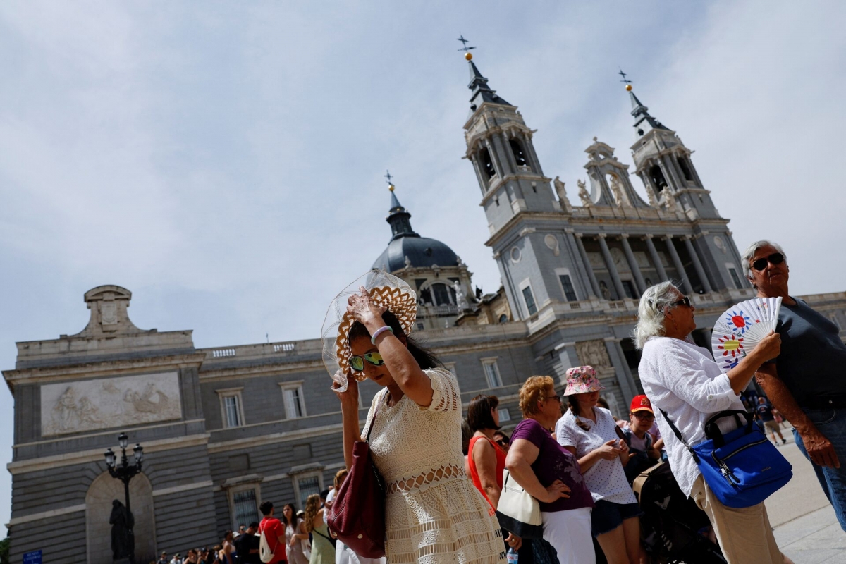 Tourists use fans and hats for sun protection outside La Almudena Cathedral during an episode of exceptionally high temperatures for the time of year in Madrid, Spain, on May 21, 2022. (Photo: REUTERS/Susana Vera)