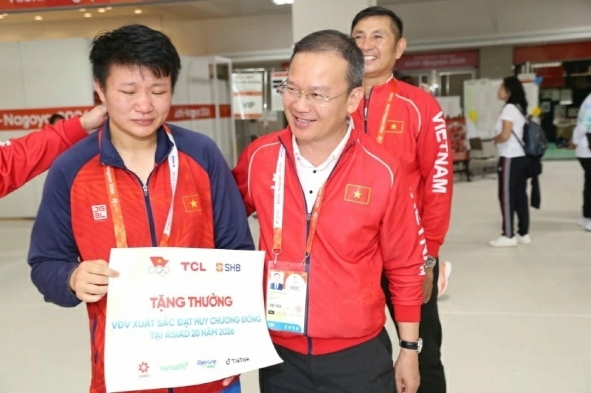Head of the Vietnamese boxing team hands over a reward to boxer Luu Diem Quynh. (Photo: Tam Ninh)