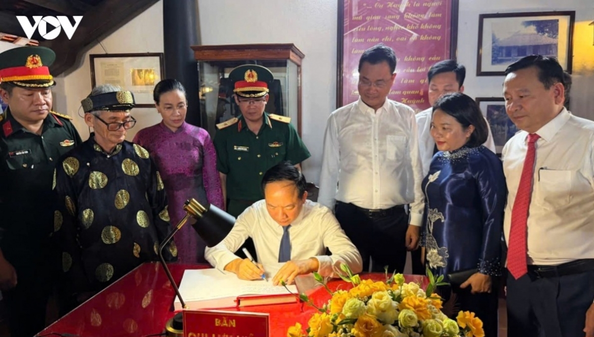 Trưởng Ban Tuyên giáo Trung ương Trịnh Văn Quyết ghi sổ lưu niệm. Ảnh: VOV
