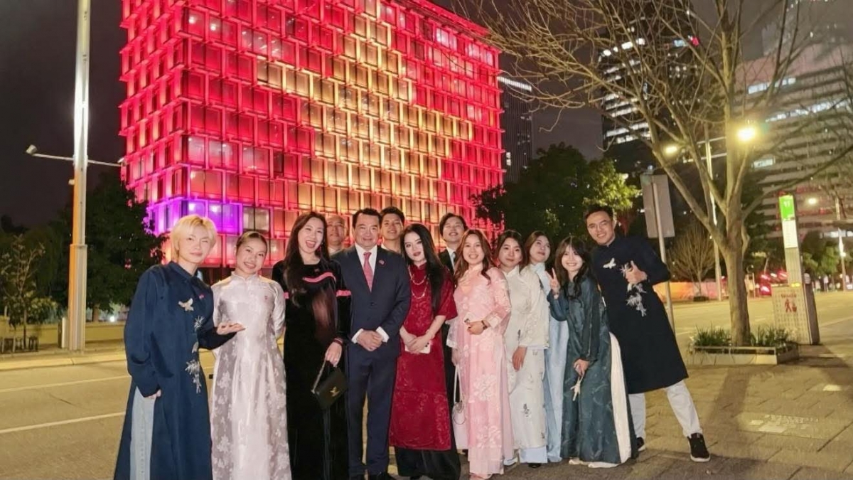 Consul General Pham Hai Anh and some members of the Vietnamese community in Perth pose for a photo in front of Perth Town Hall, with Vietnam’s national flag projected onto its facade.