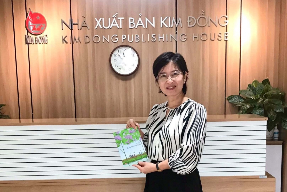 Dương Hà với cuốn sách đồng thoại Vùng trời tím biếc của chị.