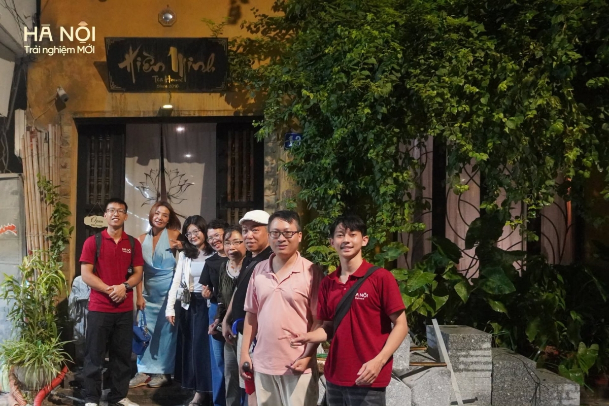  Members of the “Hanoi Night Walk” tour project (in red polos) pose for photos with tourists in the Old Quarter. (Photo: Hanoi New Experiences)