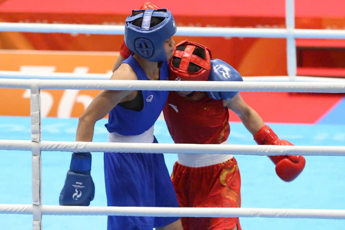 Nguyên Thi Tâm (maillot bleu) reçoit la médaille d’argent après sa défaite face à la Chinoise Wu Yu en finale des moins de 51 kg de boxe féminine aux 20es Jeux asiatiques. Photo: délégation sportive vietnamienne