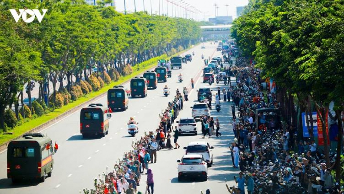 Residents stand along both sides of the road to pay their respects as the fallen heroes make their final journey to their resting place.