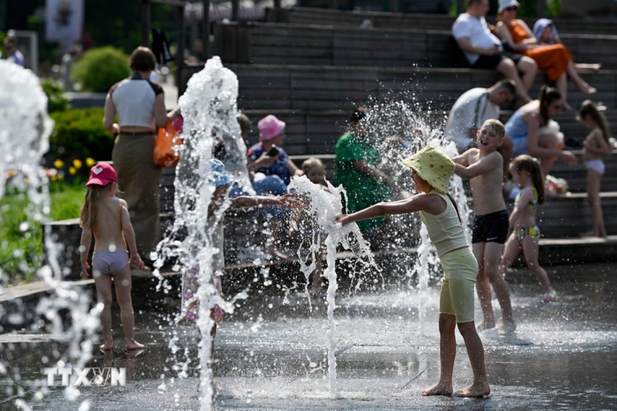 ロシア・モスクワで、噴水のそばで遊びながら暑さをしのぐ子どもたち（写真：THX/TTXVN）
