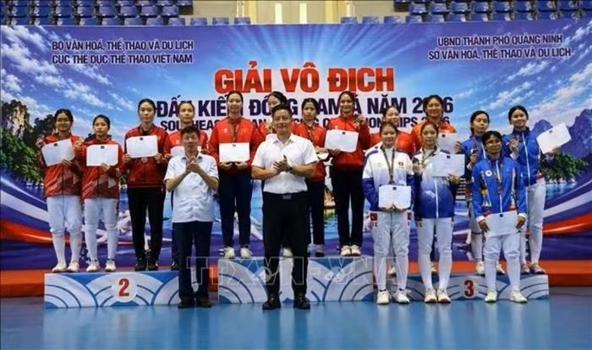 The organizing committee presents awards to the athletes in the women’s team sabre event. (Photo: VNA)