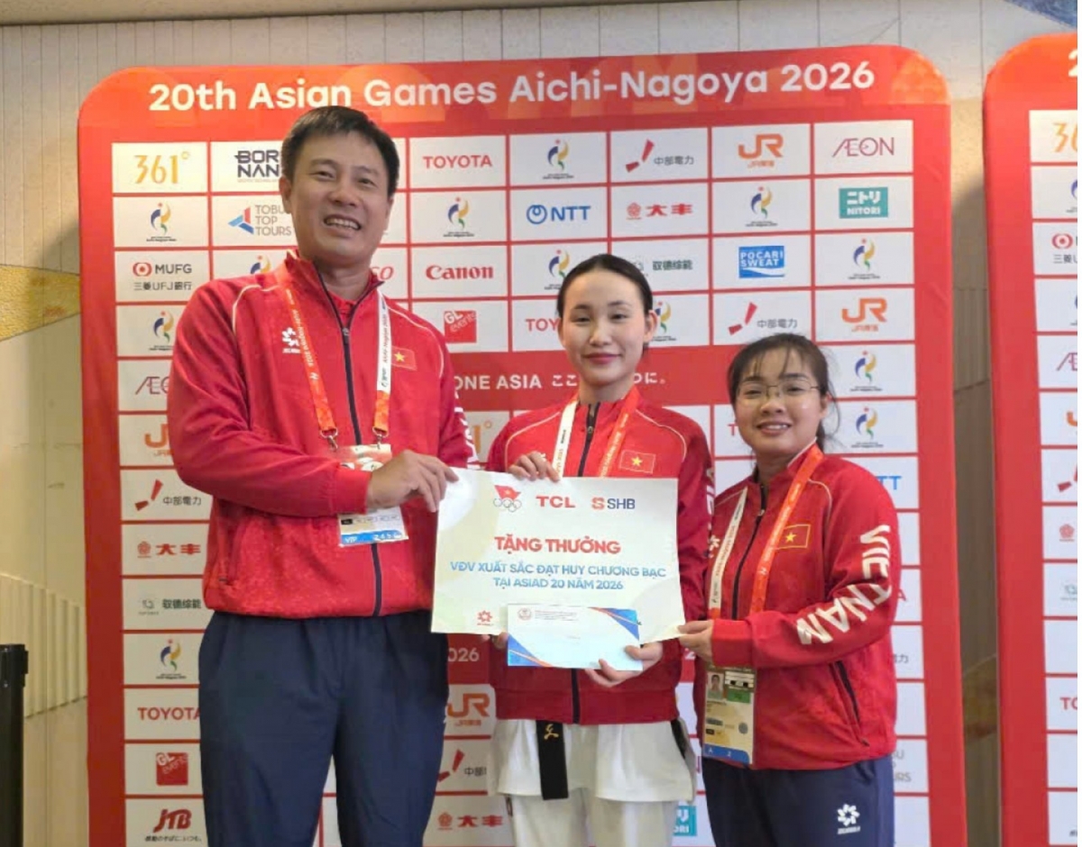 Pham Thanh Tu, Direktor des Nationalen Sporttrainingszentrums, überreicht der Kampfsportlerin Chau Ngoc Tuyet Sang eine Sofortprämie. (Foto: VOV)