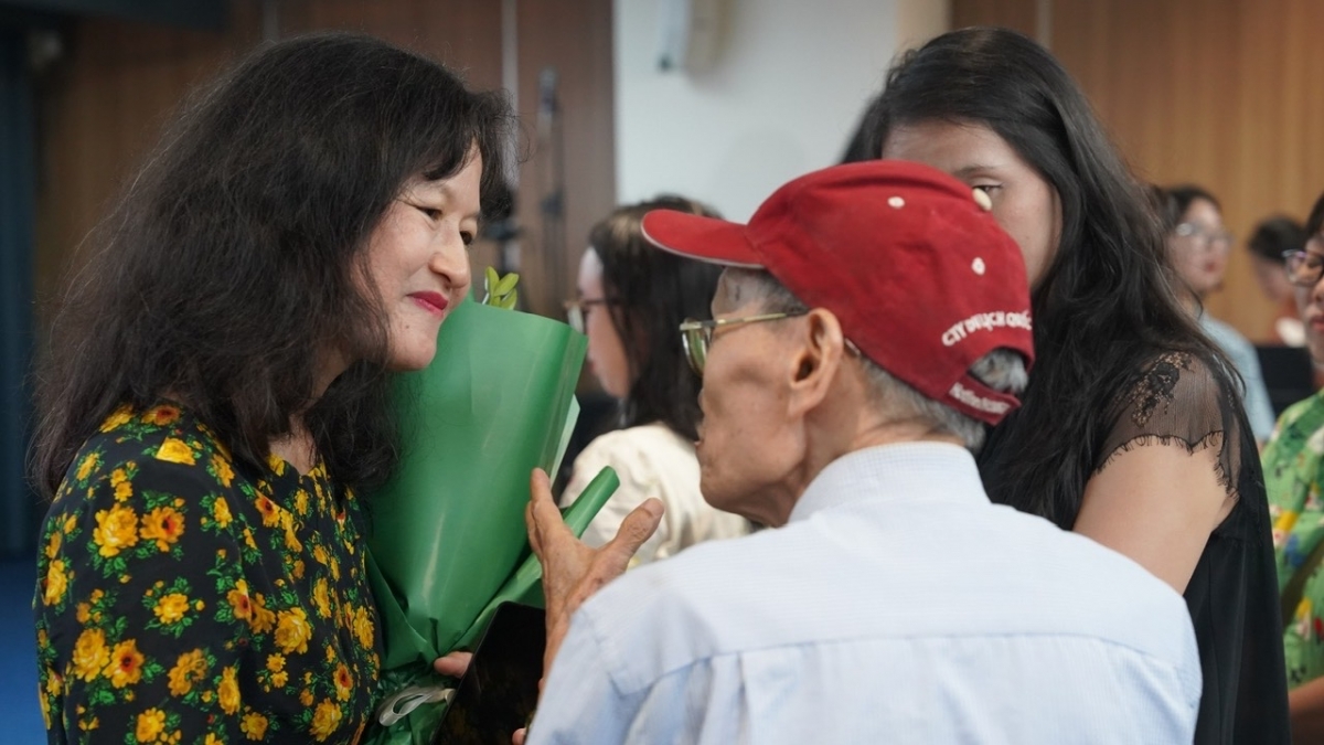 Un bouquet à la main, Doan Bui échange avec un participant à l’issue de la rencontre organisée par les éditions Kim Đồng et l’Institut français du Vietnam. Photo: Institut français du Vietnam à Hanoi
