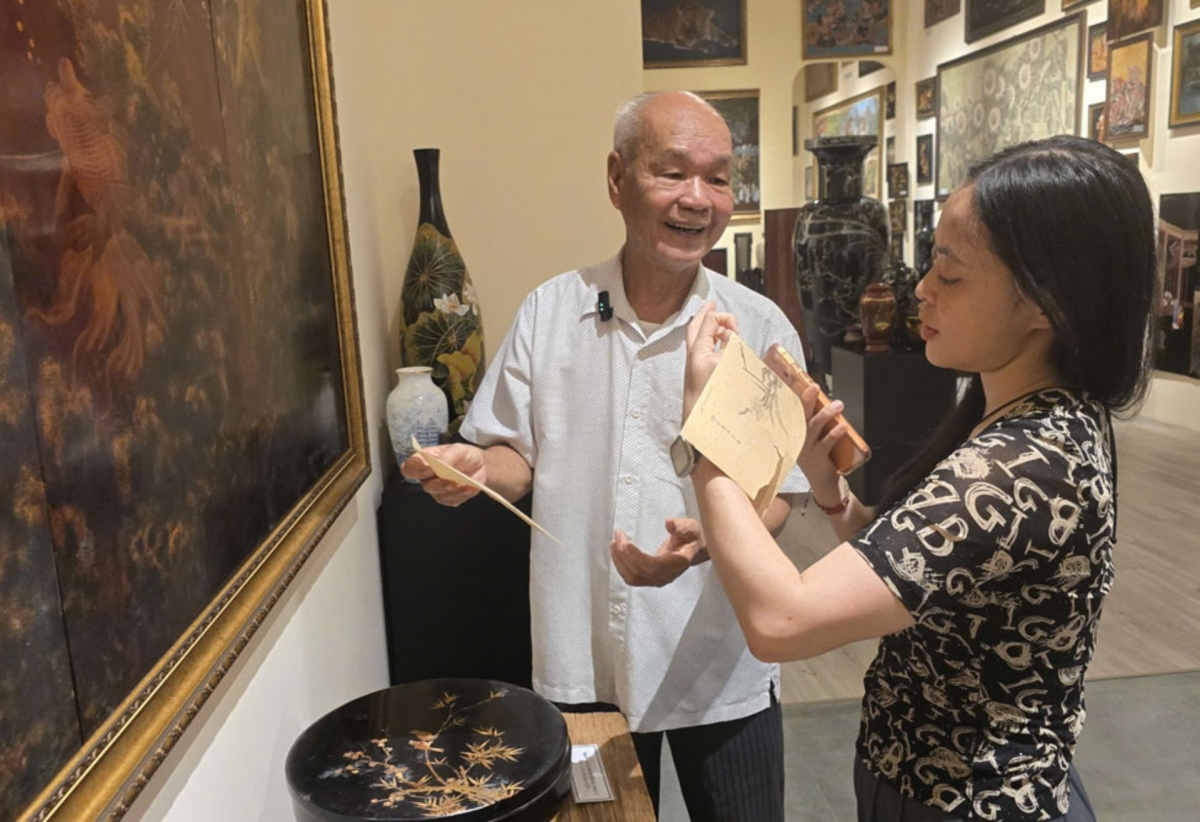 L’artisan Truong Quang Tinh (à gauche) présente ses créations en laque aux visiteurs. Photo: Thiên Ly/VOV-Hô Chi Minh-ville