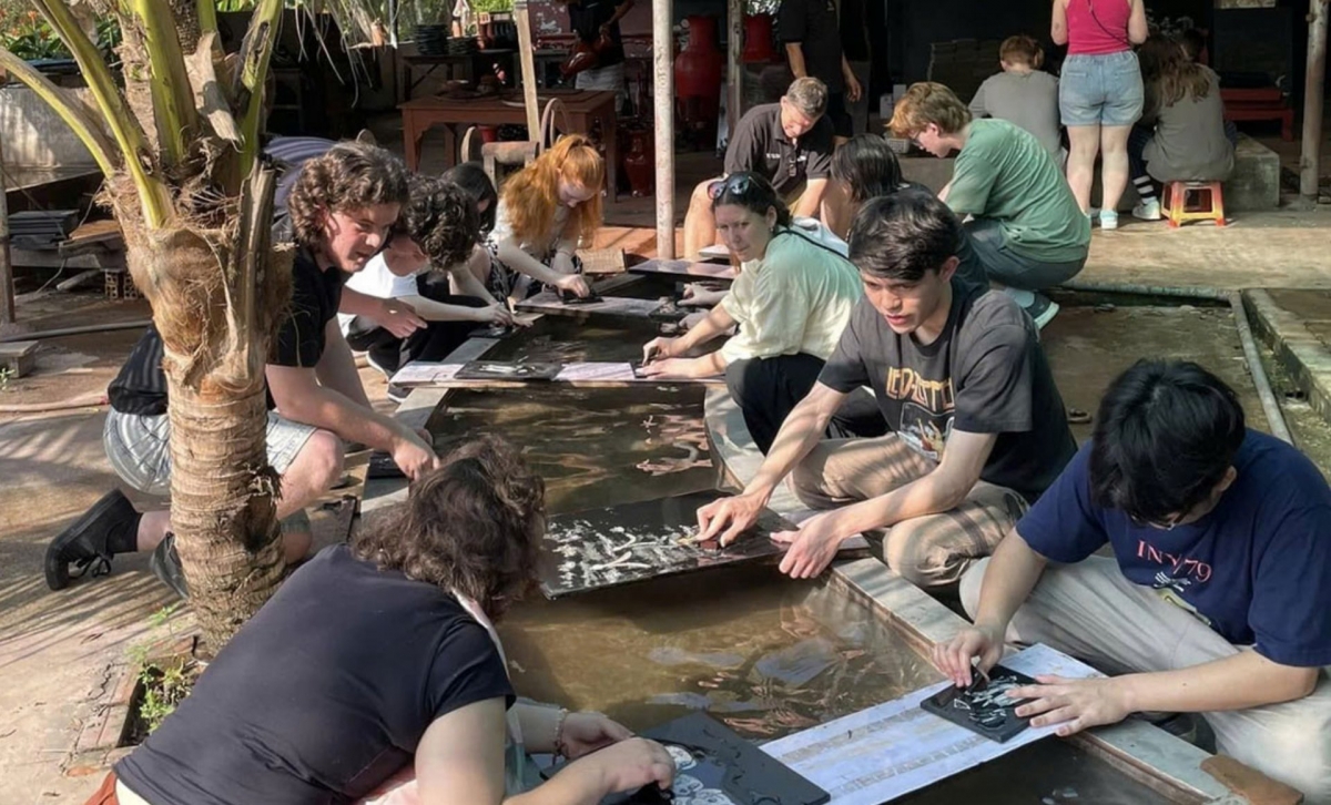 Des touristes étrangers s’initient au ponçage de la laque. Photo: Thiên Ly/VOV-Hô Chi Minh-ville