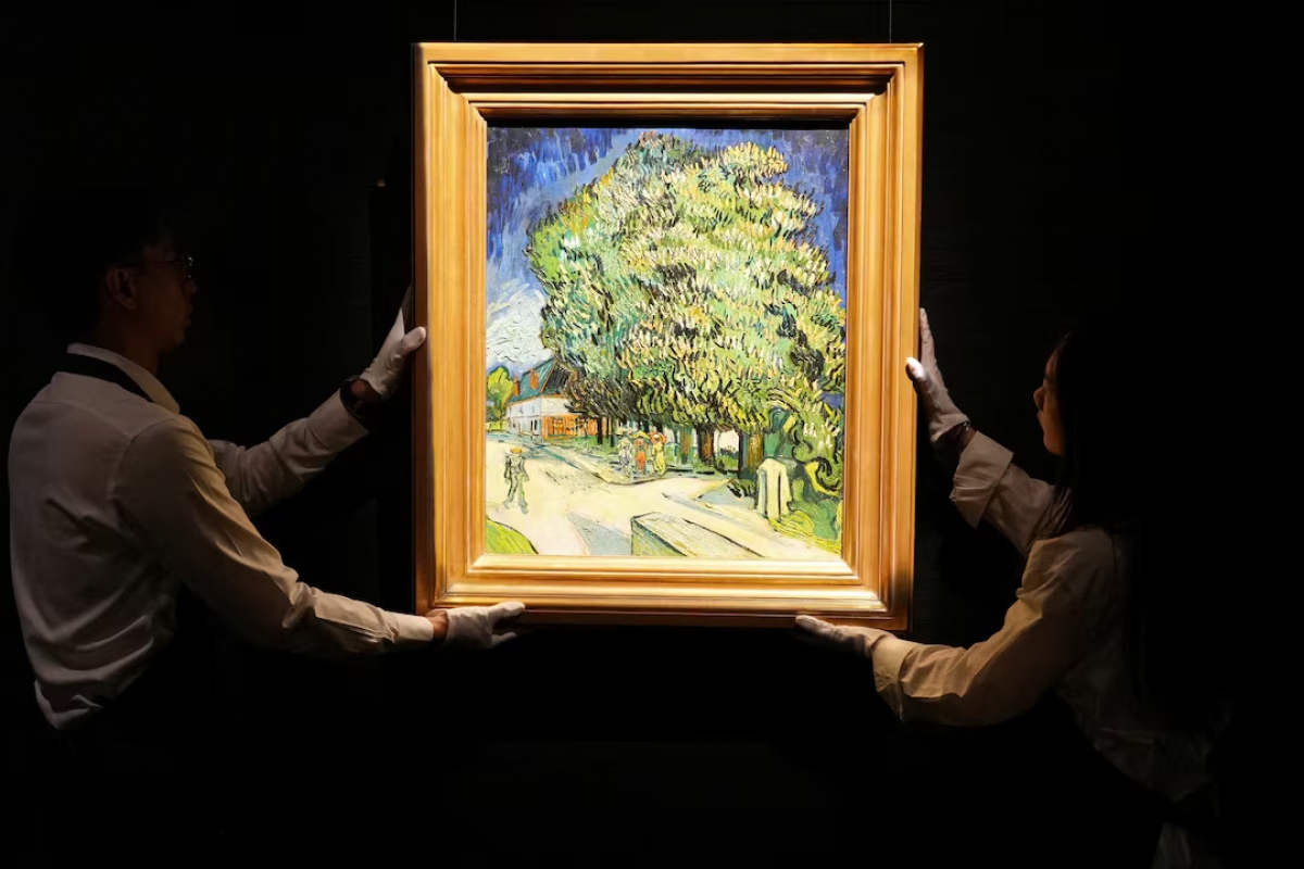 Staff members pose with Vincent van Gogh's "Chataigniers en fleurs" (Chestnut Trees in Blossom) at a media preview ahead of its auction in New York, at Sotheby's in Hong Kong, China. (Photo: REUTERS/Joyce Zhou)