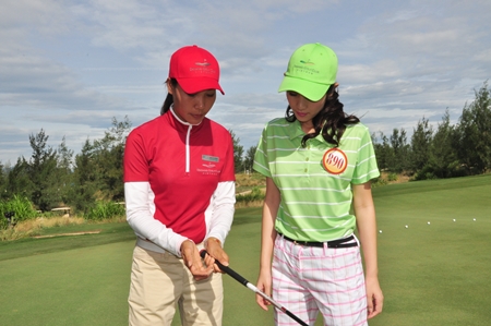 người đẹp Nguyễn Thị Hà chăm chú nghe hướng dẫn cách đánh golf