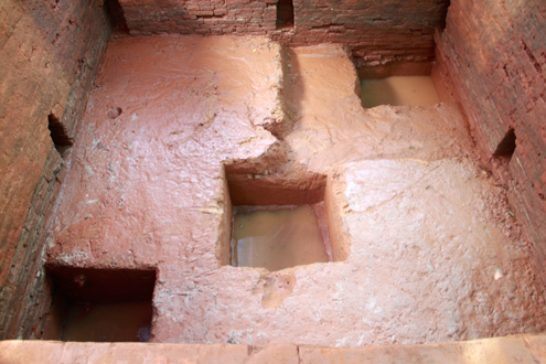 Sau gần hai tháng, Công việc khai quật được tạm dừng để có thể lập dự án nghiên cứu tiếp và đầy đủ hơn. Tại chân móng mới khảo cổ được cho thấy bề mặt khá bằng phẳng được tạo bởi một lớp gạch vụn đầm rất chắc, dày khoảng 10cm. Phía dưới lớp gạch vụn với độ dày không đều nhau đầm mặt móng đến độ sâu hơn 2m là những lớp gạch vụ đầm khác xen kẽ giữa những lớp đá cuội và cát trắng. Dưới cùng là sinh thổ gồm những lớp đất cát pha khá mịn và chặt. Hố vuông vừa khai quật này được các nhà khảo cổ gọi là hố thiêng, tức là nơi đặt bệ thờ của tín ngưỡng Ấn độ giáo.