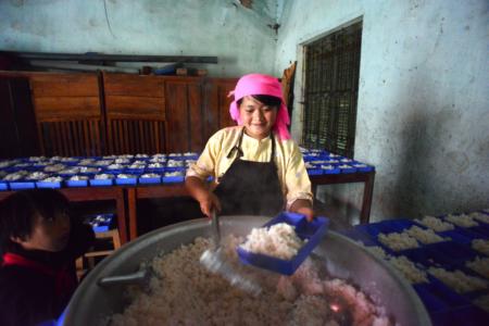 Lầu Thị May đang chia cơm cho học sinh - em là một trong 5 người 