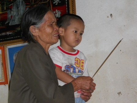 Cháu Nguyễn Quang Tuấn Anh ngơ ngác khi nghe bà nói “bà mang bố mẹ về cho cháu rồi đó”.