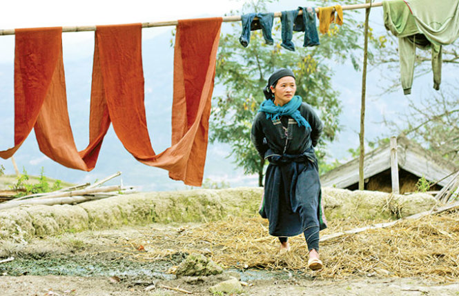 Vải sau khi dệt được nhúng chàm để tạo màu, sau đó phơi trên những chiếc sào tre bên hiên nhà