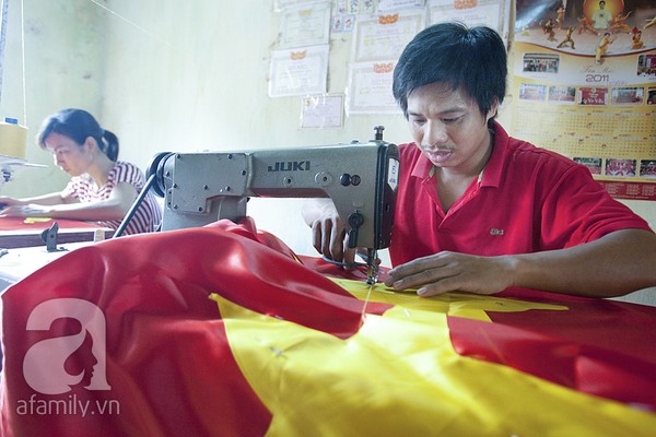 Keluarga yang menjahit Bendera Nasional Vietnam